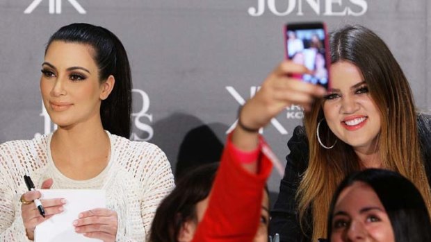 Wave reviews ... two young fans strike a pose in front of Kim and Khloe Kardashian at David Jones yesterday.