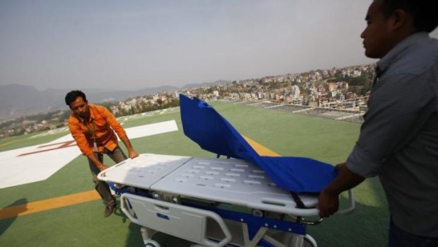 Response: Hospital staff get ready to receive the injured on the helipad of Grande hospital, in Kathmandu, Nepal.