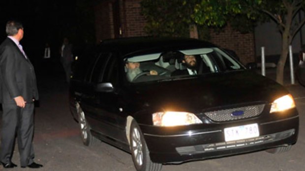Security guards surround a hearse containing Richard Pratt's body as it is taken by rabbis from Raheen tonight.