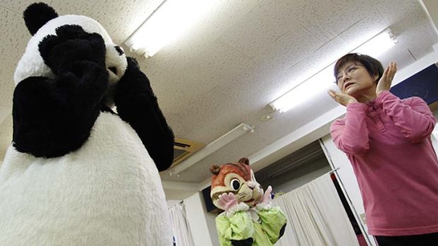Choko Oohira (R) teaches trainees how to become theme park character mascots at the Choko Group mascot school.