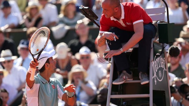 Novak Djokovic appeals to the chair umpire.