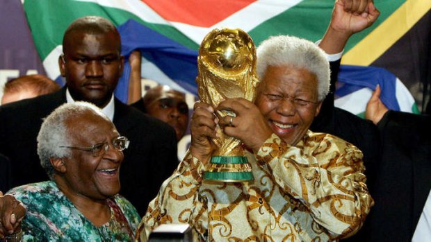 Archbishop Tutu (left) watches Nelson Mandela raise the World Cup.