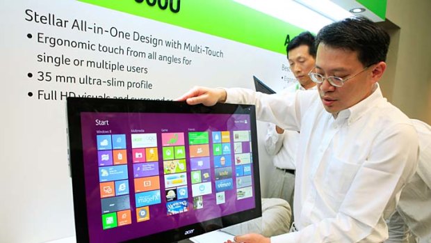 An attendant demonstrates using an Acer Aspire 7600U touchscreen computer at a news conference in Taipei, Taiwan, on Monday, June 4, 2012.