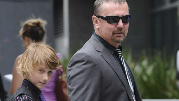 John Tyson, father and husband of flood victims Jordan and Donna Rice, walks with Blake Rice outside the Brisbane Coroners Court during an inquest into the floods.