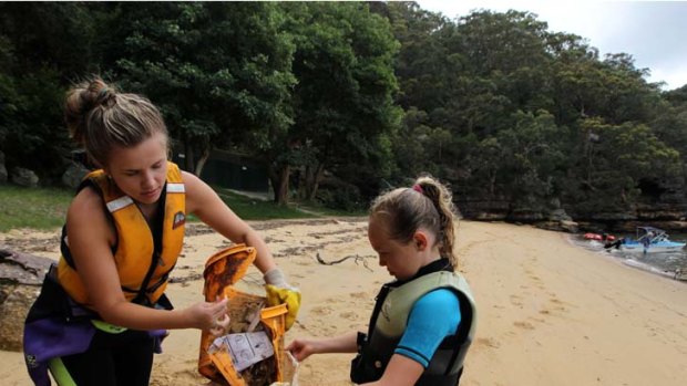 Helping hands cleaning the sands ... volunteers Hayley Burgess, left, and Taylor Crowther, from Kincumber Youth Centre, get stuck into the clean-up.
