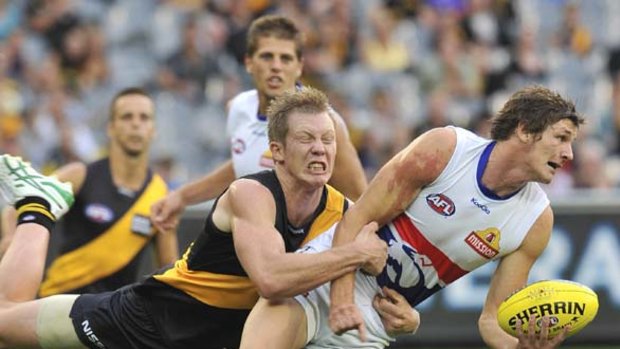 Bulldog Andrejs Everitt tries to break a tackle from Richmond's Jack Riewoldt at the MCG.
