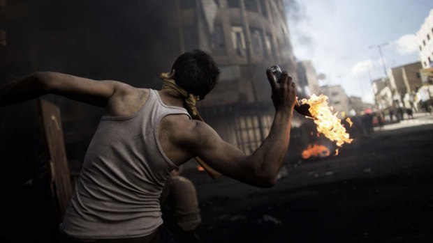 Funeral anger: A Palestinian demonstrator throws a petrol bomb towards Israeli security forces.