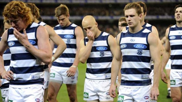 Captain Cameron Ling leads a dejected Gary Ablett and the rest of the Geelong team off the ground after the loss against Collingwood.