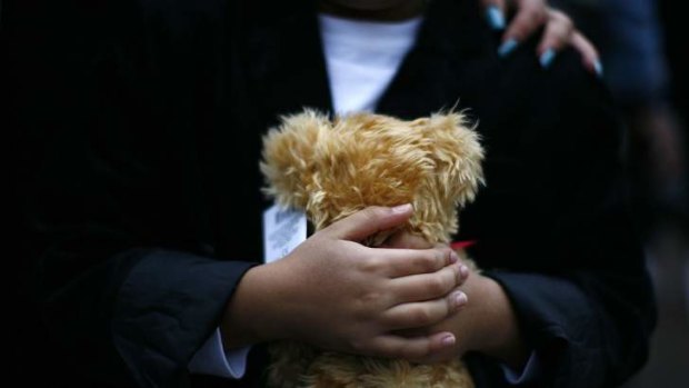 A boy holds on to a stuffed toy bear at Sandy Hook Elementary School where President Barack Obama attended an interfaith vigil.