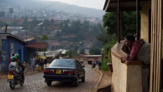 Slowly rebuilding their lives: A woman stands on her porch at a suburb set on a hill overlooking Kigali, Rwanda's capital.
