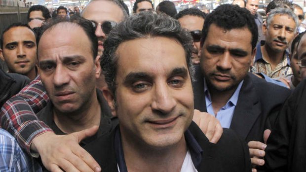 Bassem Youssef, surrounded by supporters, enters Egypt's state prosecutors office to face accusations of insulting Islam and President Mohamed Mursi.