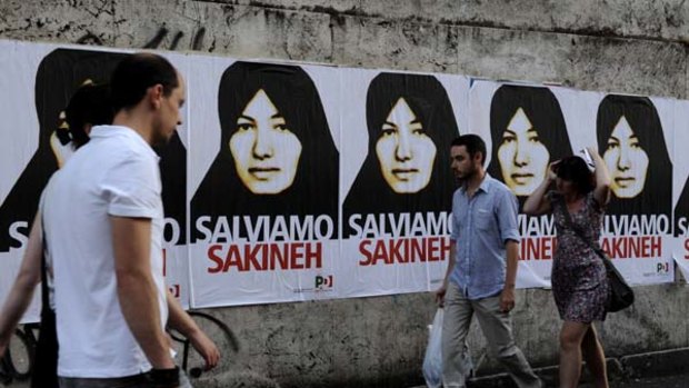 People walk by posters of Sakineh Mohammadi-Ashtiani.