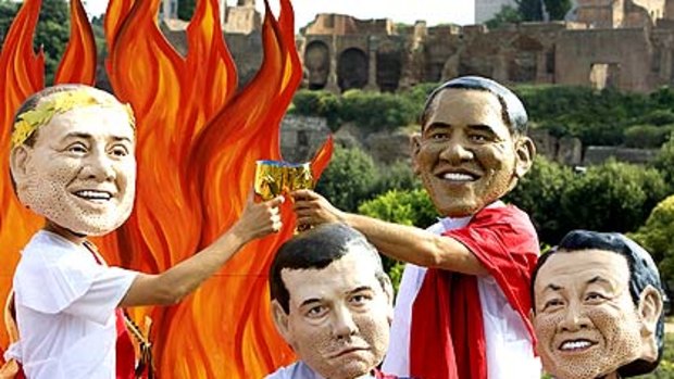 Oxfam activists wear masks depicting Silvio Berlusconi, Dmitry Medvedev, Barack Obama and Japan's Taro Aso.