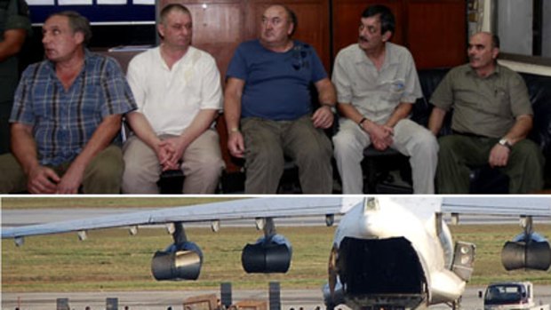 Deadly cargo... Thai security personnel surround a cargo plane loaded with weapons, thought to be bound for Pakistan or the Middle East. Five men were arrested (top).