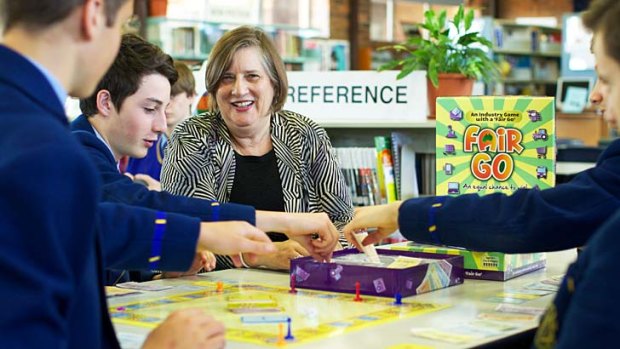 Thrill of the game: Year 9 students from Waverley College, from left, Daniel Keneally, Sam Hodge and Harrison Kyriakou play a new board game invented by Andrea Thompson, pictured.