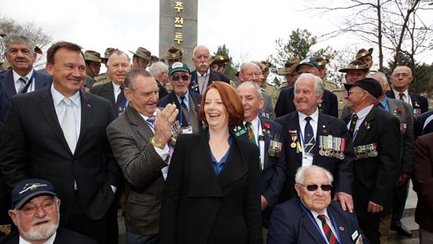Victoria Cross winner Keith Payne jokes with Prime Minister Julia Gillard at the commemoration of the 60th anniversary of the Battle of Kapyong in South Korea.