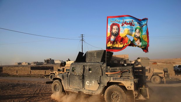 An Iraqi special forces vehicle carries a Shiite flag near Mosul in November.