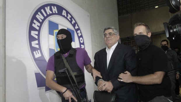 Far-right Golden Dawn party leader Nikos Mihaloliakos (centre) is escorted by anti-terrorism police officers as he leaves the Greek police headquarters in Athens September 2013.