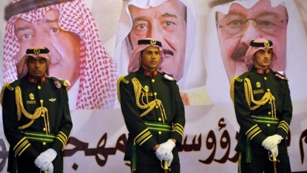 Saudi royal guards stand on duty in front of portraits of the country's rulers at a cultural festival this week.