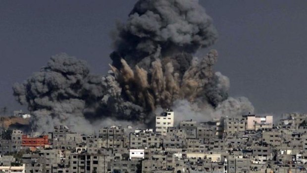 Costly rebuilding: heavy smoke billows following an Israeli military strike in Gaza City.