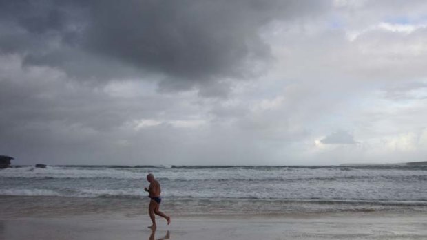 Calm before the storm ... an early morning swimmer braves the weather on deserted Bondi Beach. Strong winds and heavy seas are expected over the next few days.