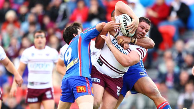 Manly's George Rose takes a couple of Newcastle defenders with him on his team's way to a resounding 32-10 win over the Knights.