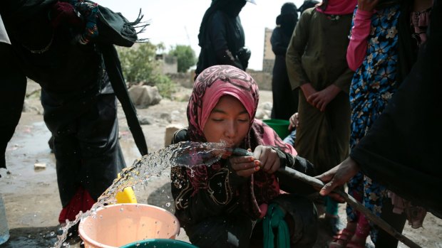 A girl drinks water from a well believed contaminated with the bacterium Vibrio cholera, on the outskirts of Sanaa.