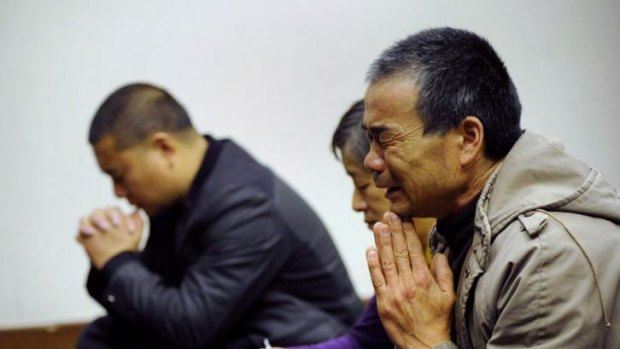 Relatives of MH370 passengers from the flight pray before a meeting in Beijing in March.