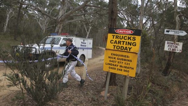 Police leave a restricted area leading to the crime scene where possible human remains have been found.