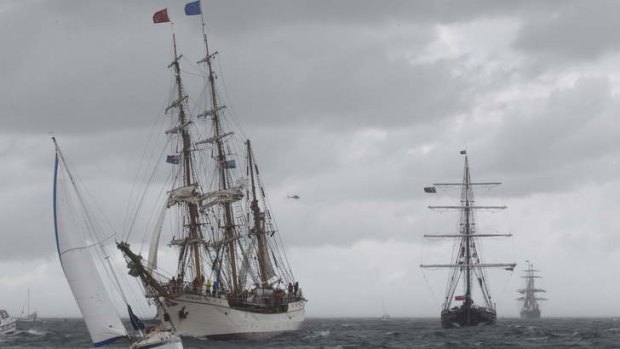 Under a lowering sky: Tall ships the Bark Europa from the Netherlands, Spirit of New Zealand and James Craig from Australia sail into Sydney Harbour.