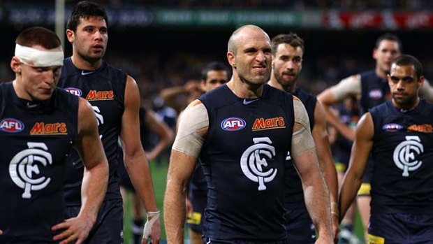 So close: Carlton skipper Chris Judd leads the vanquished Blues from the field after their 3-point loss to West Coast in the first semi-final in Perth last night.