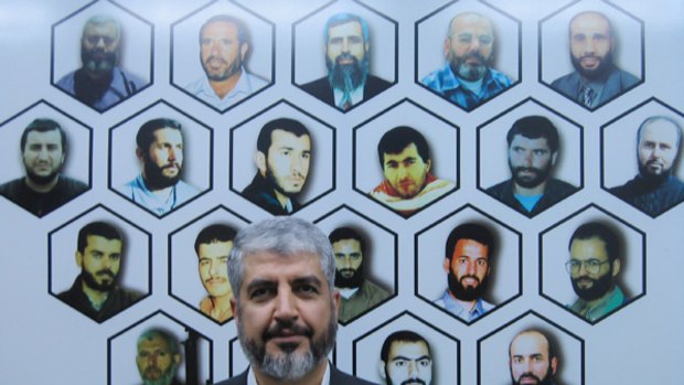 Khalid Mishal in his office, its walls decorated with the portraits of Hamas "martyrs"  killed by Israel.