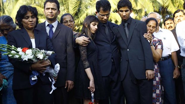 Husband, Benedict Barboza, holds his son Junal, right, and daughter Lisha, during the burial of nurse Jacintha Saldanha in her hometown Shirva, near Mangalore in southwest India.
