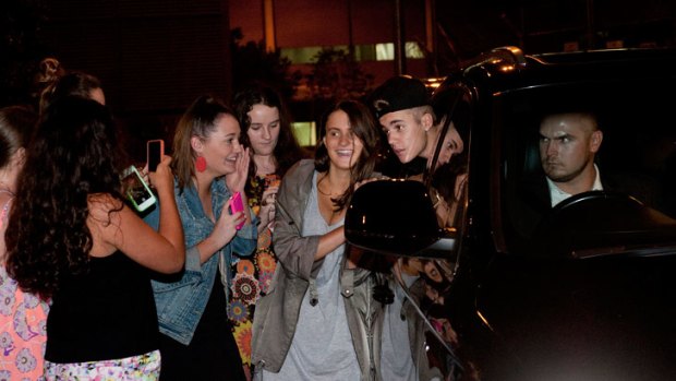 Justin Bieber poses for photos with fans after arriving at Brisbane Airport.