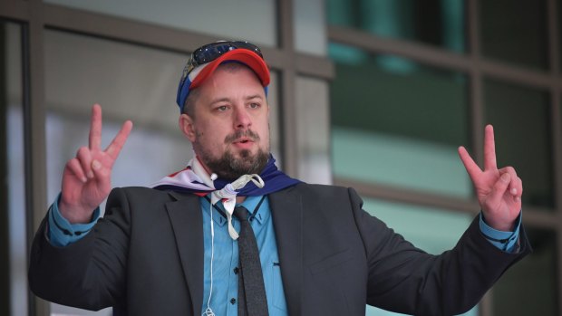 Neil Erikson, wrapped in an Australian flag, outside the Melbourne Magistrates Court in September 2017.