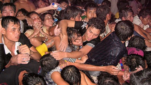 People reach for help from the crush at a water festival that brought millions to Phnom Penh.