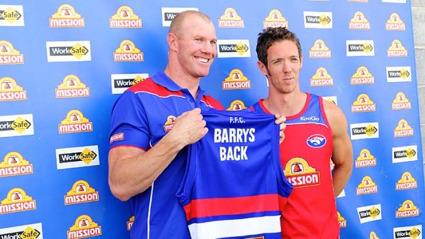 Once bitten: Barry Hall (left) receives his guernsey from Bob Murphy in his welcome back to the kennel yesterday.