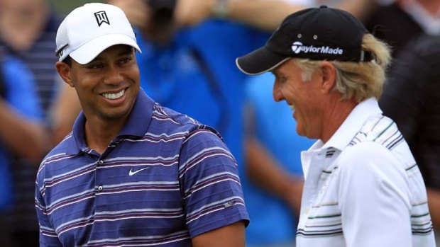 In good spirits ... Tiger Woods shares a joke with Greg Norman yesterday, having earlier cleared the air with his former caddy.