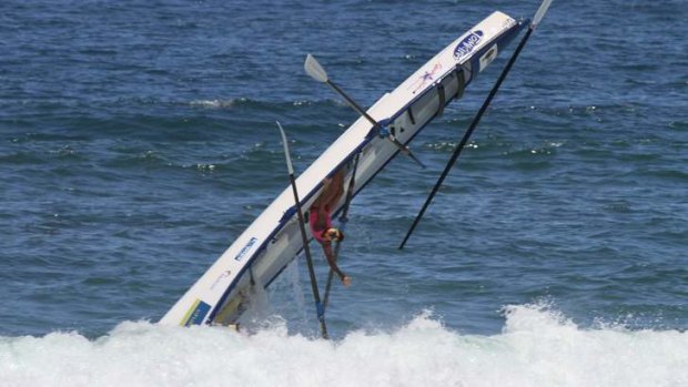 Pete Williams of Kawana Surf Life Saving Club hangs upside down as his team is dumped by a shock wave.