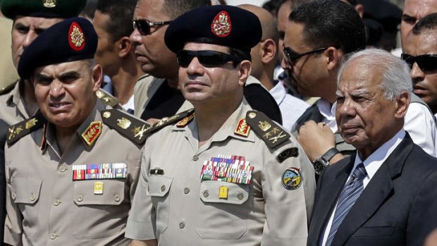 Egyptian Defence Minister General Abdel-Fattah el-Sisi, centre, and interim Prime Minister Hazem el-Beblawi, right in 2013.