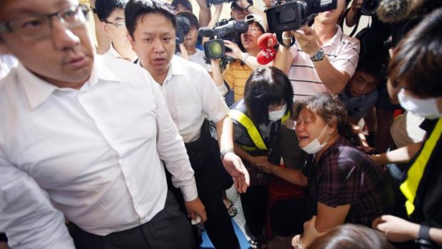 Chairman of TransAsia Airlines Vincent Lin, left, leaves after meeting a family member, right, of a victim in the TransAsia Airways flight GE222 crash on the Taiwan island of Penghu.