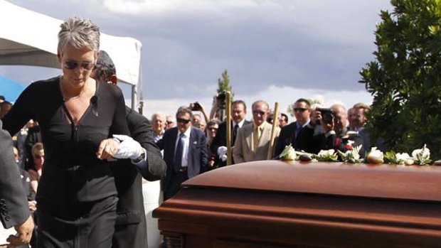 Jamie Lee Curtis is helped to the casket of her father Tony Curtis during his funeral.