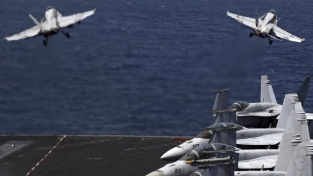 Air strikes: F/A-18 fighters take off for missions in Iraq from the deck of the USS George H.W. Bush last month.