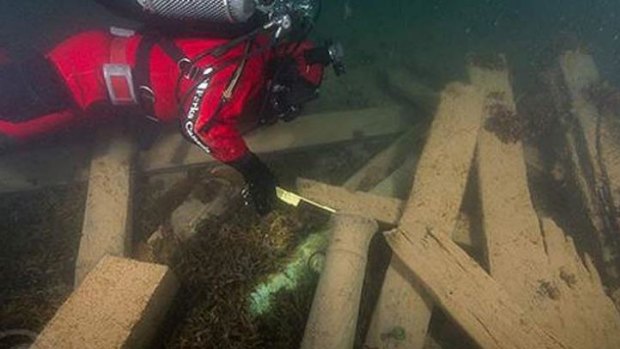 Underwater archaeologist Filippo Ronca measure one of the two cannons found on the site.