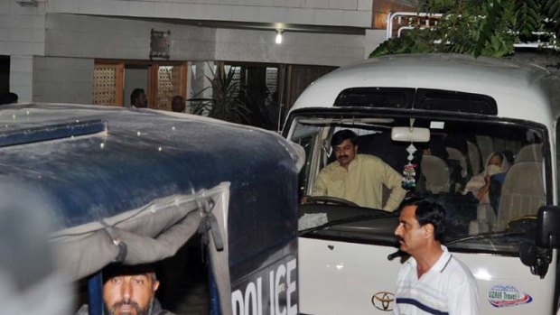 Pakistani policemen escort a minivan carrying Osama bin Laden's family.