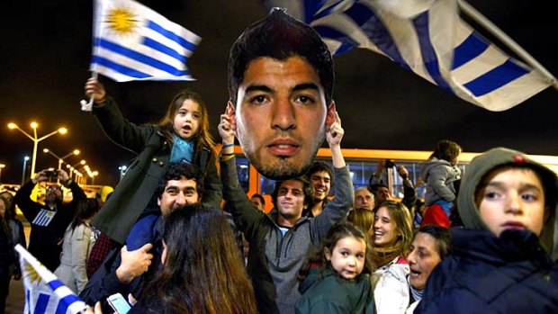 Hail to the tooth: A welcome party awaits Luis Suarez in Montevideo after he received a nine-match, four-month ban for biting an Italian player.