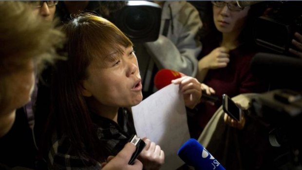 A relative of a Chinese passenger aboard the missing Malaysia Airlines Flight MH370 holds a paper which reads "Hunger strike protest, Respect life, Return my relative, Don't want become victim of politics, Tell the truth." 