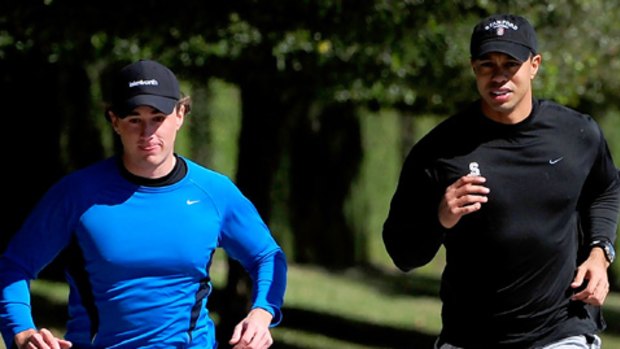 Tiger Woods jogs with an unidentified friend near his home on February 17, 2010 in Orlando, Florida.