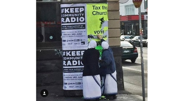 Two people dressed as nuns deface an Australian Sex Party poster in Melbourne.
