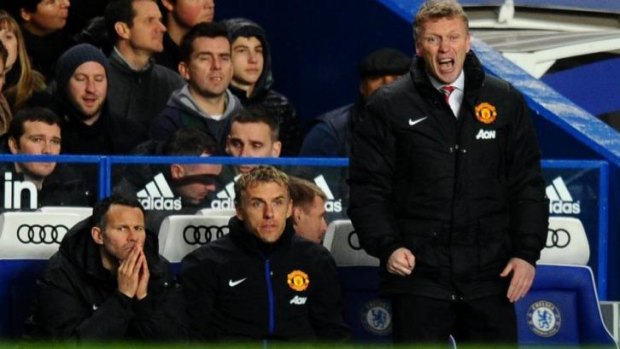 On the periphery: Ryan Giggs (L) sits on the bench as manager David Moyes screams from the sidelines.
